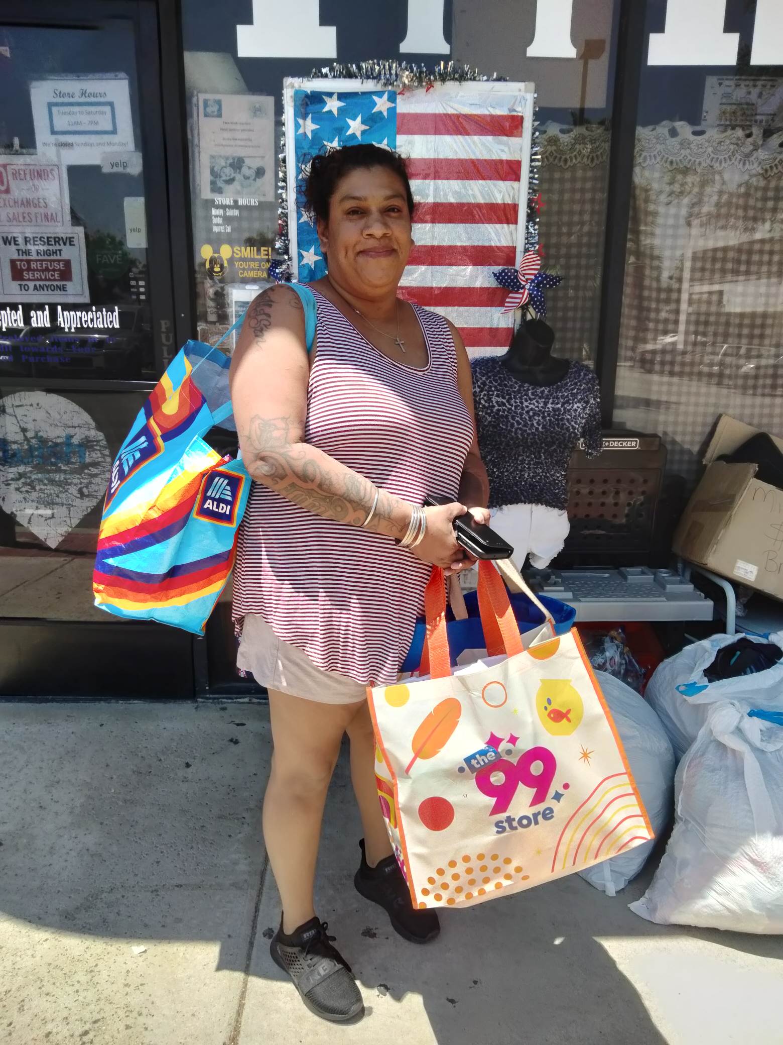 A community member outside the thrift shop holding bags of items