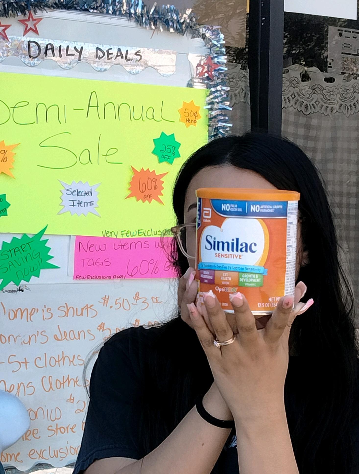 A recipient holding a container of formula in front of their face